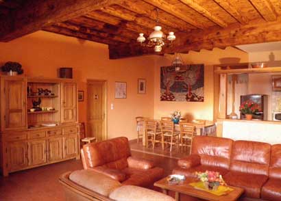 The large living room with its French-style wooden ceiling and oak table for 10 guests.