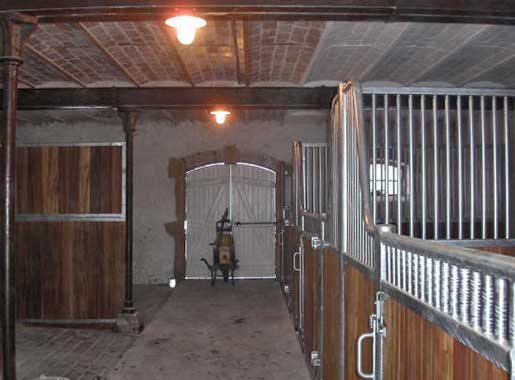 Les écuries du gîte avec box, espace douche, sellerie. La porte du fond donne directement sur un pré de 3 ha.